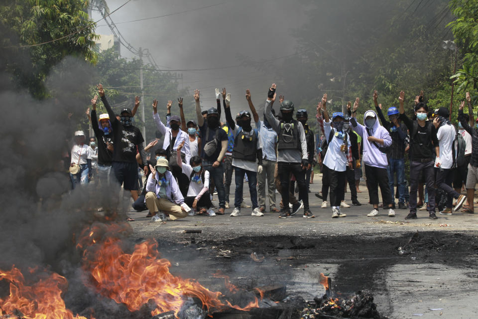 Anti-coup protesters gesture with a three-fingers salute, a symbol of resistance during a demonstration during by police crack down in Thaketa township Yangon, Myanmar, Saturday, March 27, 2021. (AP Photo)