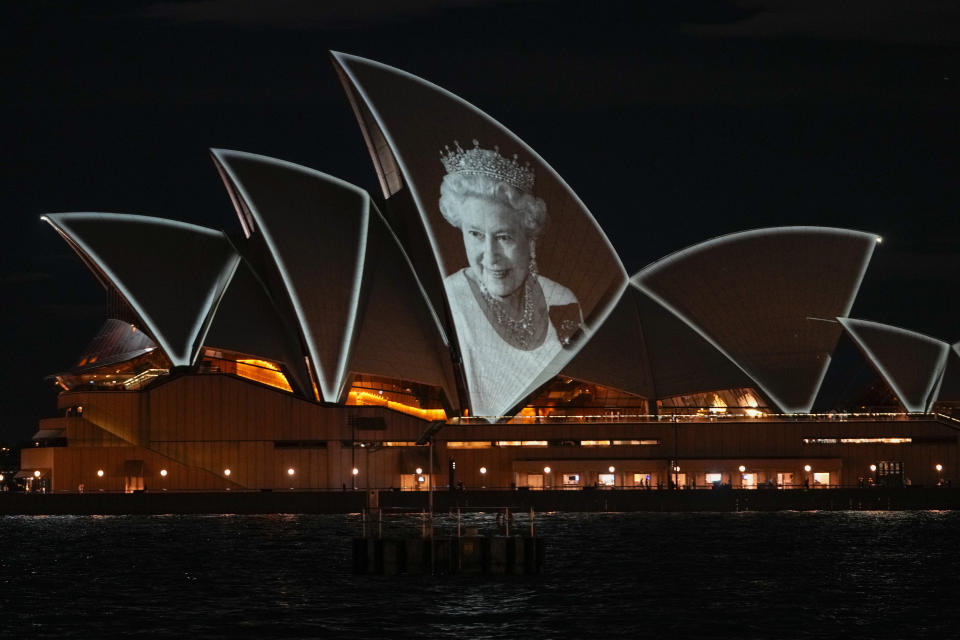 La ópera de Sydney es iluminada con un retrato de la reina Isabel II en Sydney, Australia, el viernes 9 de septiembre de 2022. La reina Isabel II, la monarca con el reinado más largo de Gran Bretaña y una roca de estabilidad en buena parte de un siglo turbulento, falleció el jueves 8 de septiembre de 2022 tras 70 años en el trono. Tenía 96 años. (Foto AP/Mark Baker)