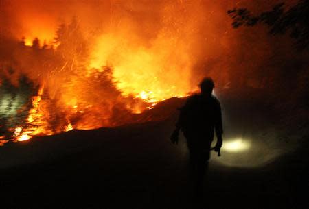 A firefighter uses a headlamp at the Rim Fire at night in this undated United States Forest Service handout photo near Yosemite National Park, California, released to Reuters August 30, 2013. REUTERS/Mike McMillan/U.S. Forest Service/Handout via Reuters