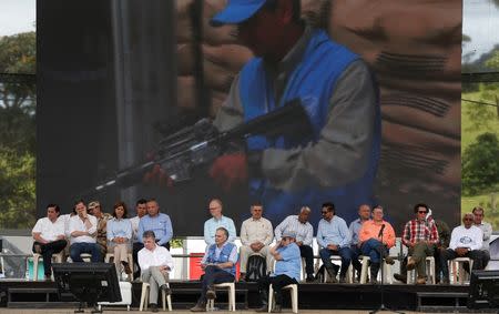 Colombia's Marxist FARC rebel leader Rodrigo Londono, known as Timochenko, (R), Colombian president Juan Manuel Santos (L) and the UN Secretary-General's Special Representative for Colombia and Head of the UN Mission to Colombia, Jean Arnault (C) attend the final act of abandonment of arms in Mesetas, Colombia June 27,2017. REUTERS/Jaime Saldarriaga
