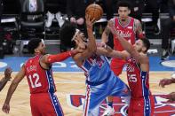 Brooklyn Nets' Jarrett Allen (31) shoots between Philadelphia 76ers' Ben Simmons (25) and Tobias Harris (12) during the second half of an NBA basketball game Thursday, Jan. 7, 2021, in New York. (AP Photo/Frank Franklin II)