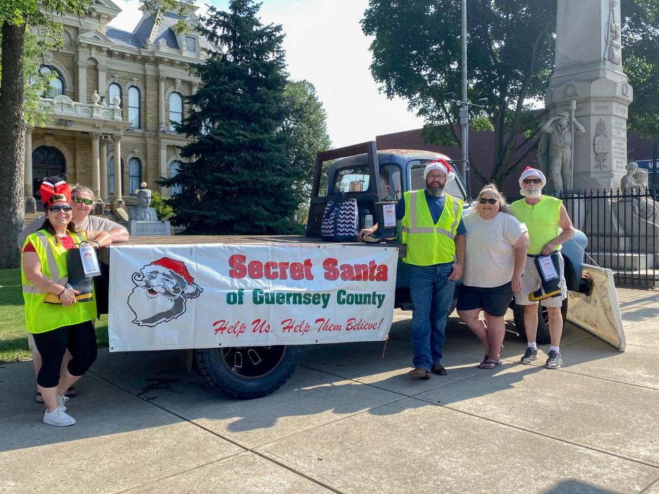 Kasey Crooks, Melissa Wheeler, William Johnston, Tammy Ball and Gerry Shaffer help out at the Christmas in July Wheeling Avenue boot drive for Secret Santa.