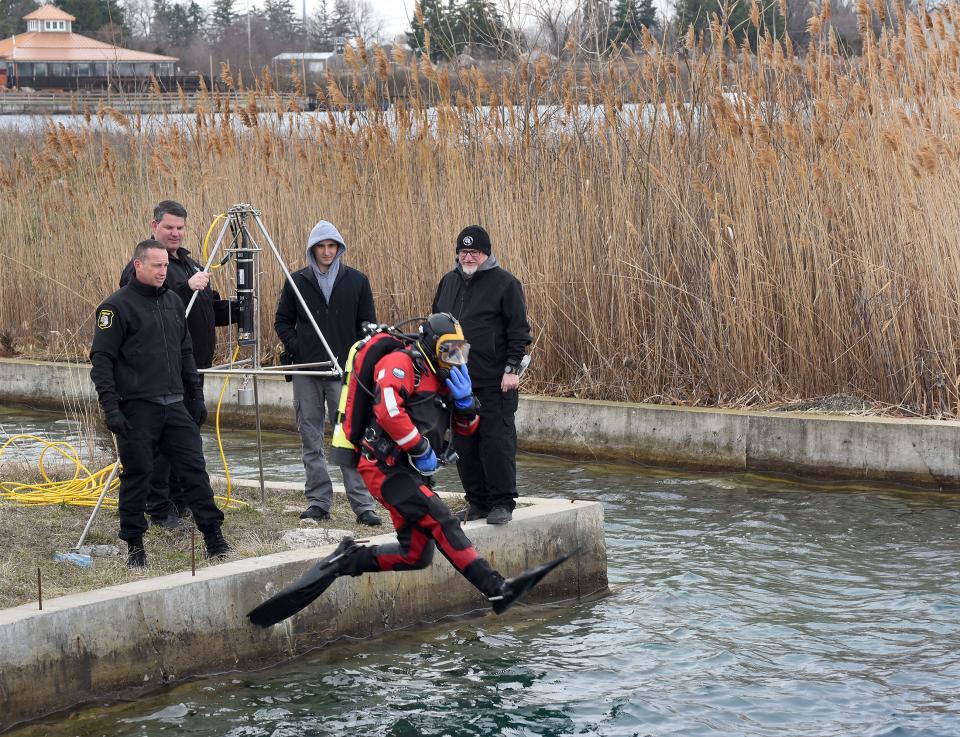Monroe County Sheriff's Office Lt. Brian Francisco, Deputy Dave Moore, Deputy Mike Stahl and diver Brian Paules watch as diver LaSalle Fire Capt. Dave Brown jumps into Lake Monroe. They will then lower, for the first time, the new Kongsberg MS 1000 360-degree sonar machine.