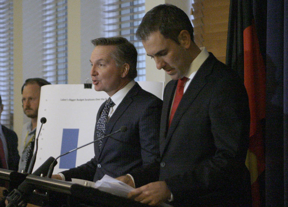 Opposition center-left Labor Party lawmakers Chris Bowen, left, and Jim Chalmers on Friday, May 10, 2019, outline in Parliament House in Canberra, Australia, policy to reduce tax breaks for landlords and some shareholders which they argue would save 154 billion Australian dollars ($108 million) over the next decade. Australia's opposition party has promised to deliver bigger budget surpluses than the government if it wins elections next week, while the ruling coalition warns the policies would harm the economy. (AP Photo/Rod McGuirk)