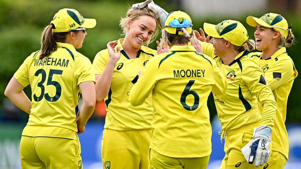 Kim Garth celebrates her wicket against Ireland with Australian teammates.