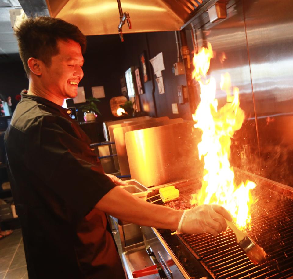 The previous owner and chef Sotheavong Meas cooks on the grill at Malis in Raynham on Tuesday, July 19, 2022.