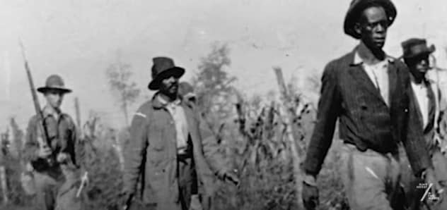 Black sharecroppers walk in Phillips County, Arkansas