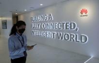 FILE PHOTO: A Huawei's staff uses her smartphone at the telecommunication company's Customer Experience Centre in Kuala Lumpur