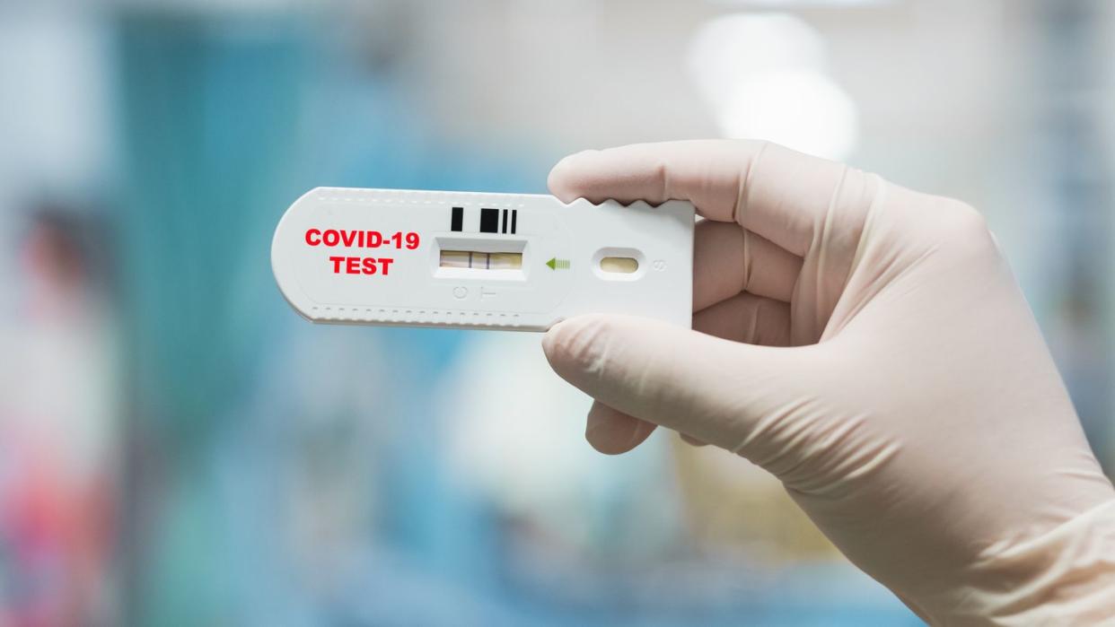 doctor hand holding positive coronavirus or covid 19 rapid test