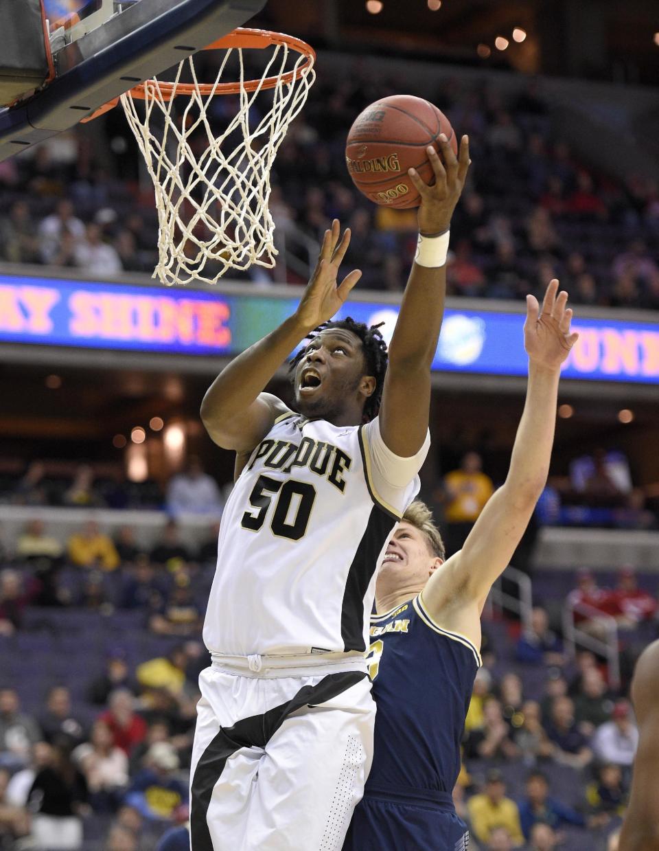 Purdue forward Caleb Swanigan (50) goes to the basket ahead of Michigan forward Moritz Wagner, right, during the first half of an NCAA college basketball game in the Big Ten tournament, Friday, March 10, 2017, in Washington. (AP Photo/Nick Wass)