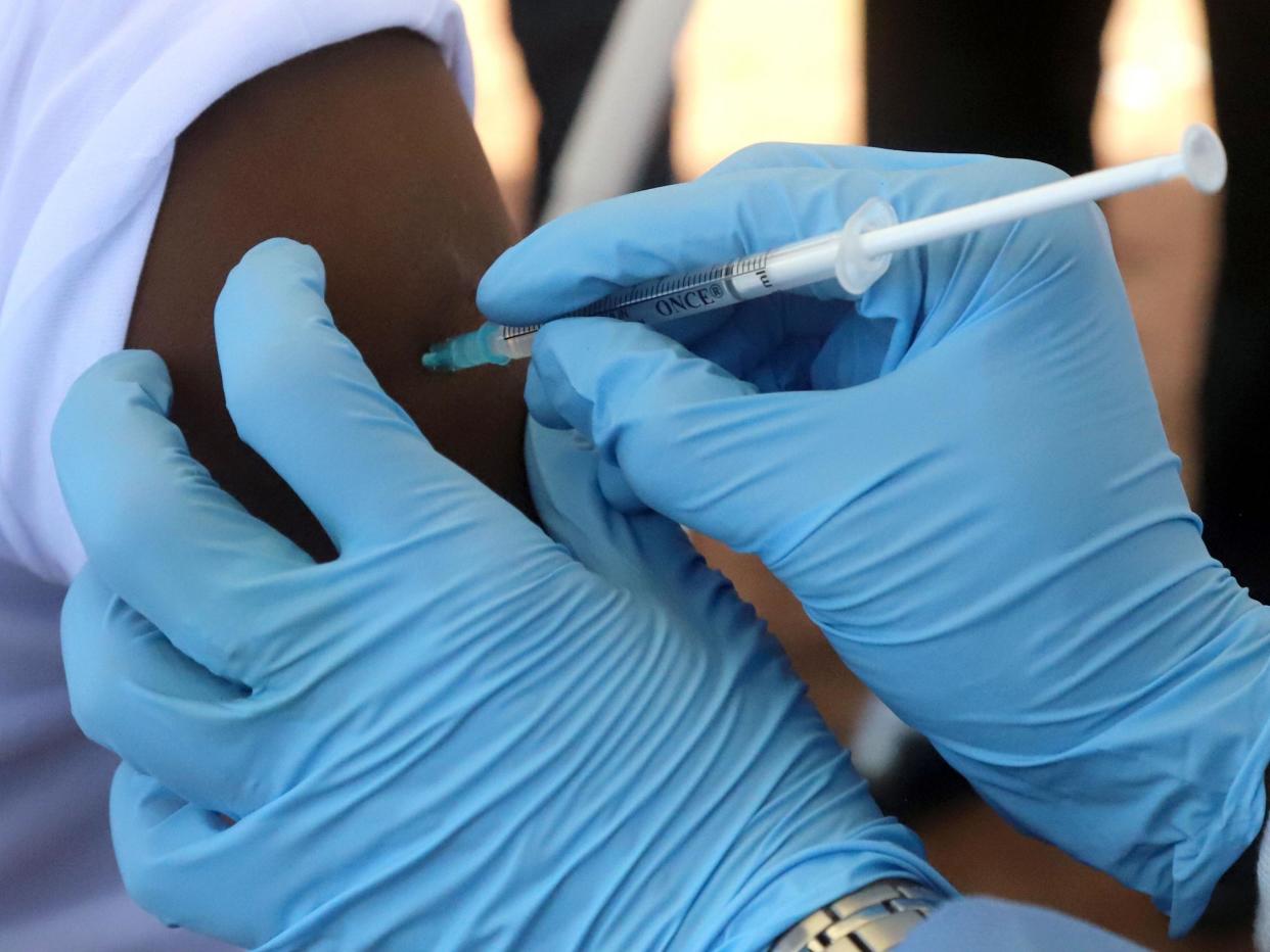A World Health Organization (WHO) worker administers a vaccination during the launch of a campaign aimed at beating an outbreak of Ebola in the port city of Mbandaka, Democratic Republic of Congo May 21, 2018: REUTERS/Kenny Katombe