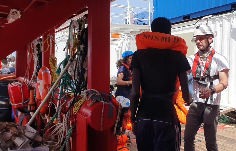 In this photo released Friday, Aug. 9, 2019, one of the 80 migrants rescued from a rubber dinghy off Libya is welcomed to the Ocean Viking rescue ship run by the SOS Mediterranee NGO. Italian Interior Minister Matteo Salvini, who has triggered a government crisis in Italy, said he is preparing to sign a ban on the ship's entry into Italian waters. (Photo SOS Mediterranee via AP)