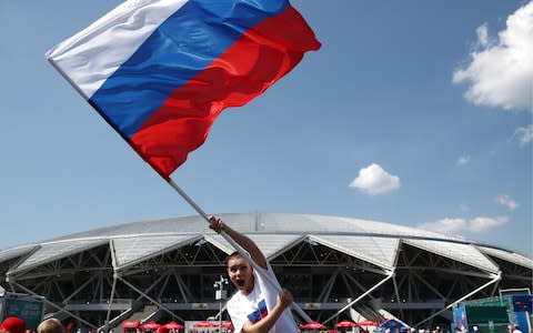 A fan of Team Russia waves the Russian flag ahead of a 2018 FIFA World Cup Group A football match between Russia and Uruguay at Samara Arena - Credit: Getty Images