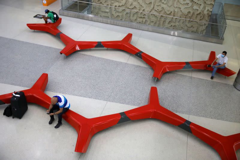 FILE PHOTO: Passengers practise 'social distancing' at a main Miami International Airport terminal