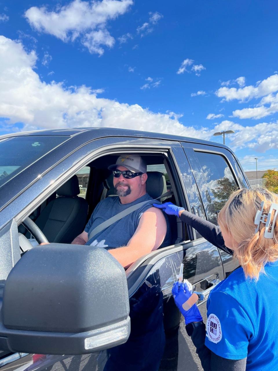 Michael Werbner prepares to receive a flu vaccine shot during a drive-thru vaccination clinics presented by the San Juan Regional Medical Center in the fall of 2023.