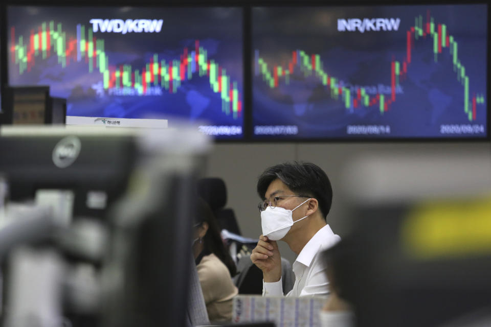 A currency trader adjusts his face mask at the foreign exchange dealing room of the KEB Hana Bank headquarters in Seoul, South Korea, Thursday, Sept. 24, 2020. Asian shares were mostly lower Thursday as caution again after a retreat on Wall Street driven by a decline in technology shares.(AP Photo/Ahn Young-joon)