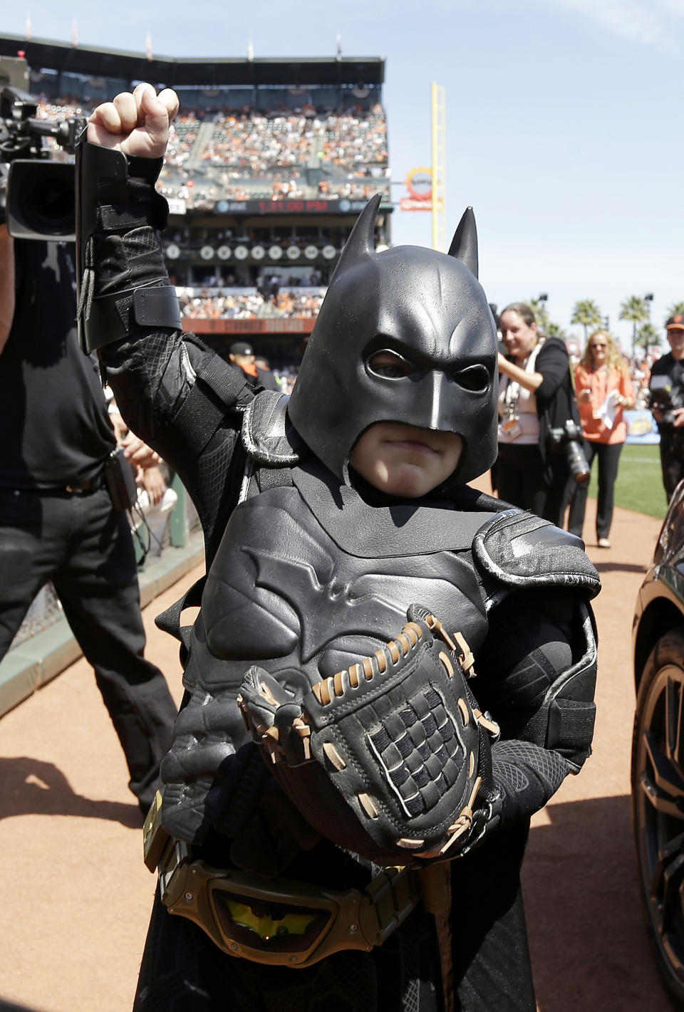 In this file photo from Tuesday, April 8, 2014, Miles Scott, dressed as Batkid, gestures after throwing the ceremonial first pitch before a baseball game between the San Francisco Giants and the Arizona Diamondbacks in San Francisco. On the five-year anniversary of then-5-year-old Miles Scott capturing the hearts of millions by saving the day in San Francisco as Batkid, his Make-A-Wish Foundation dream accomplished at last, the fifth-grader is thriving. (AP Photo/Eric Risberg, Pool)