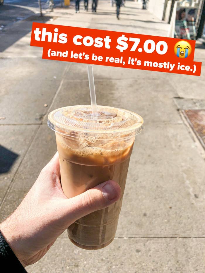 author holding up iced coffee in plastic cup with text "this cost $7.00, and let's be real, it's mostly ice."