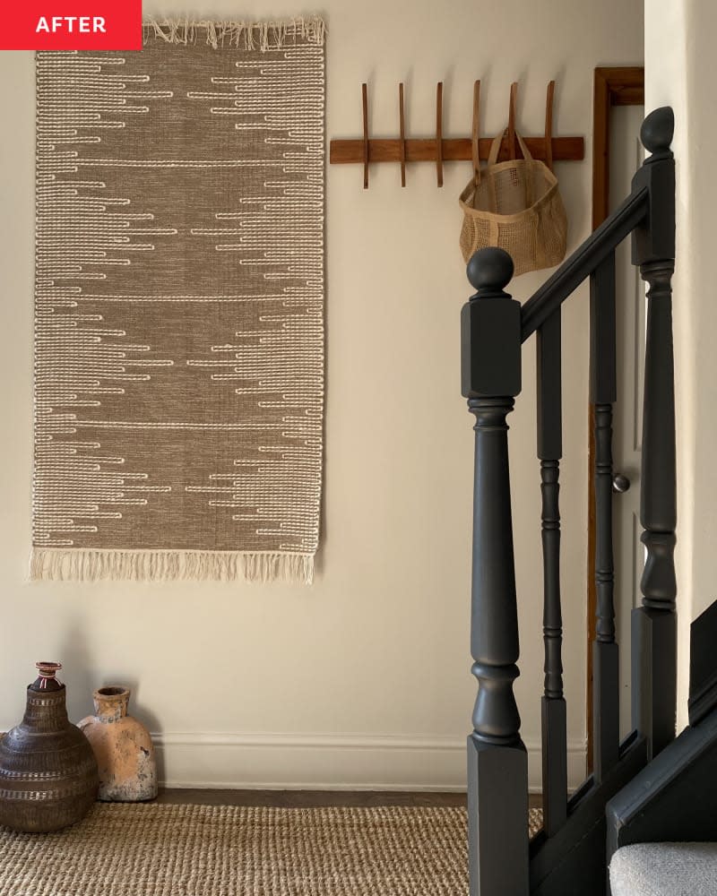 dark teal banister with beige textiles and wooden coat rack on wall