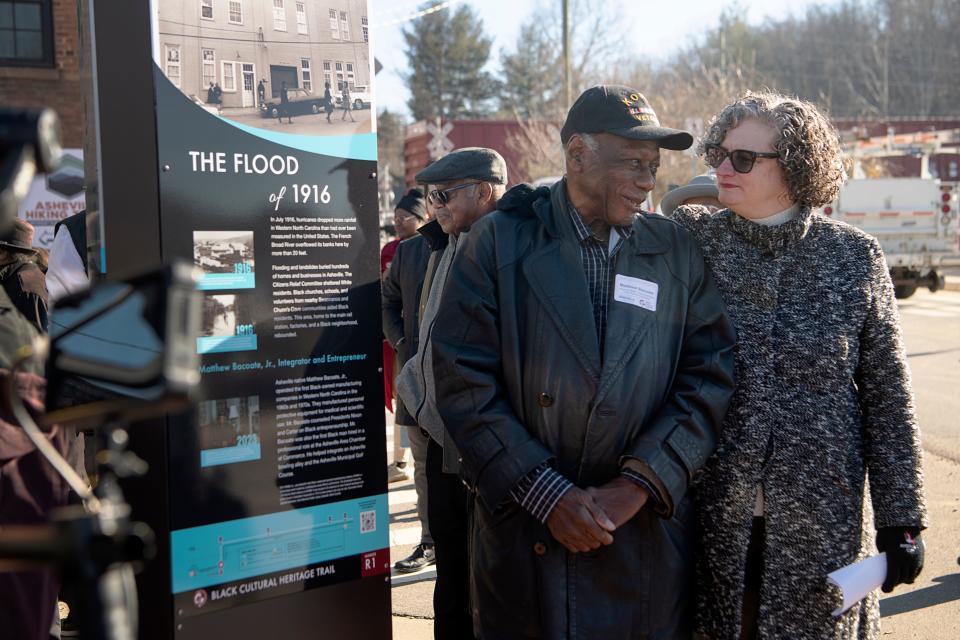 Korean War veteran and life-long Asheville resident, Matthew Bacoate Jr., stands next to the unveiled historical marker featuring himself, with President and CEO of Explore Asheville, Vic Isley, December 15, 2023.