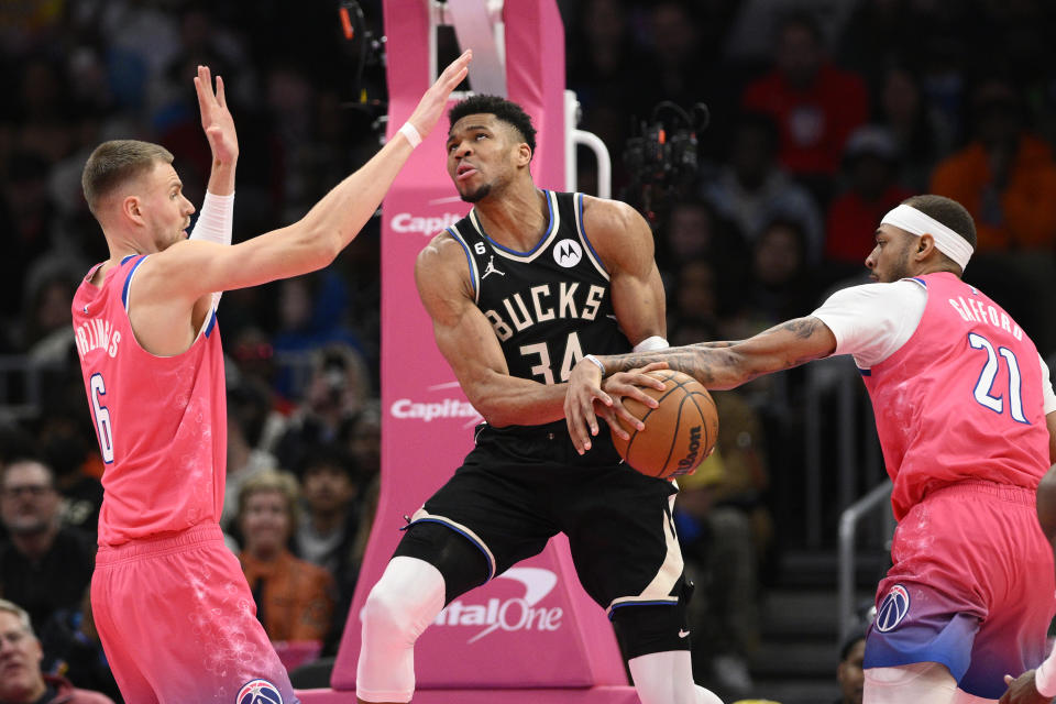 Milwaukee Bucks forward Giannis Antetokounmpo gets fouled by Washington Wizards center Daniel Gafford (21) during the second half of an NBA basketball game, Sunday, March 5, 2023, in Washington. Wizards center Kristaps Porzingis is at left. The Bucks won 117-111. (AP Photo/Nick Wass)