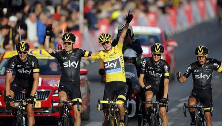 Team Sky rider Chris Froome of Britain (C), the race leader's yellow jersey, celebrates his overall victory with team-mates after the 109.5-km (68 miles) final 21st stage of the 102nd Tour de France cycling race from Sevres to Paris Champs-Elysees, France, July 26, 2015. REUTERS/Stephane Mahe