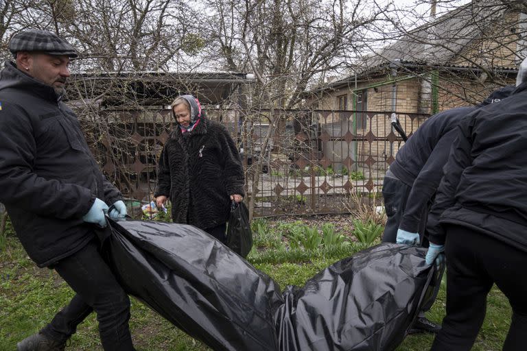 Un grupo de personas carga el cuerpo de un civil asesinado en Bucha, Ucrania.