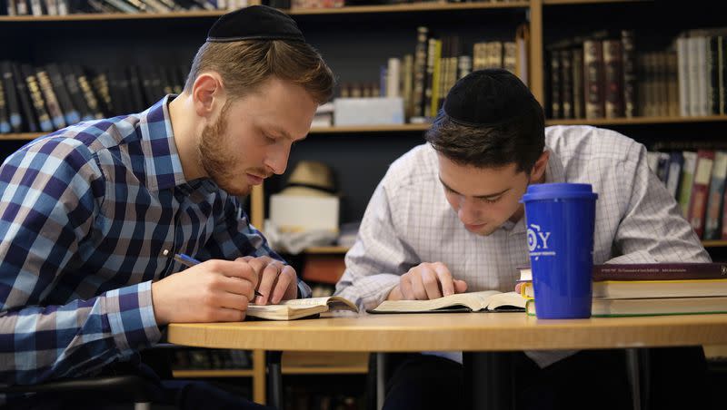 Yeshiva University students Aaron Heideman, left, and Marc Shapiro study in the university’s library in New York on Dec. 12, 2019.