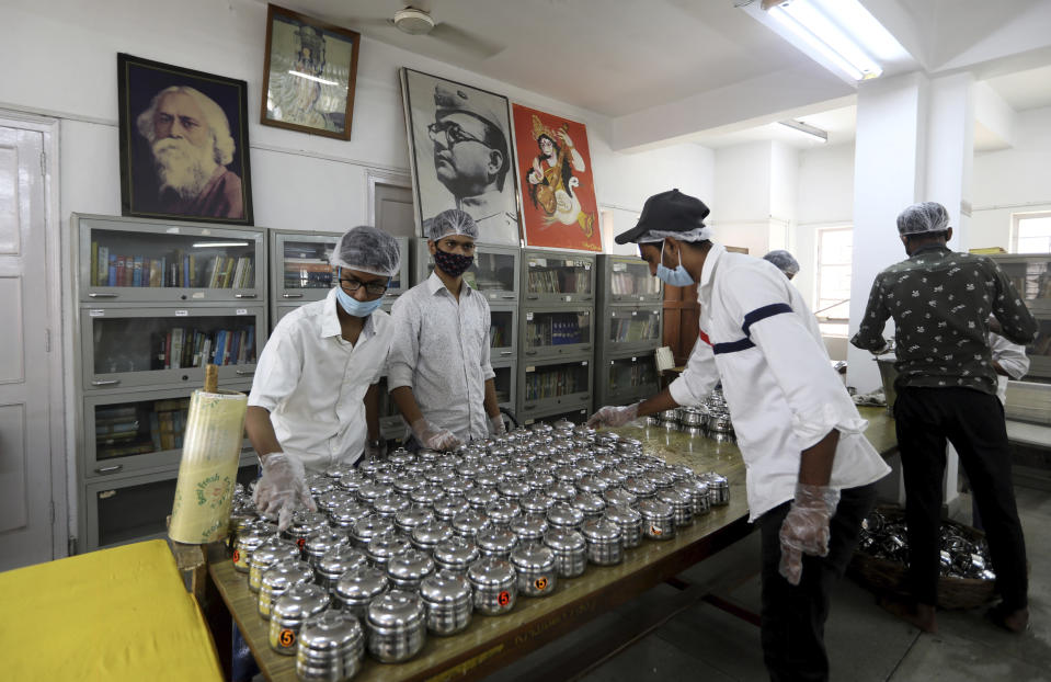 Volunteers pack prasad, or devotional offering made to a deity typically consisting of food that is later shared among devotees, to be sent to the homes of devotees in an effort to prevent large gatherings at the temple during the Durga Puja festival in New Delhi, India, Thursday, Oct. 22, 2020. Weeks after India fully opened up from a harsh lockdown and began to modestly turn a corner by cutting new infections by near half, a Hindu festival season is raising fears that the disease could spoil the hard-won gains. Health experts worry the festivals can set off a whole new cascade of infections, further testing and straining India’s battered health care system. (AP Photo/Manish Swarup)