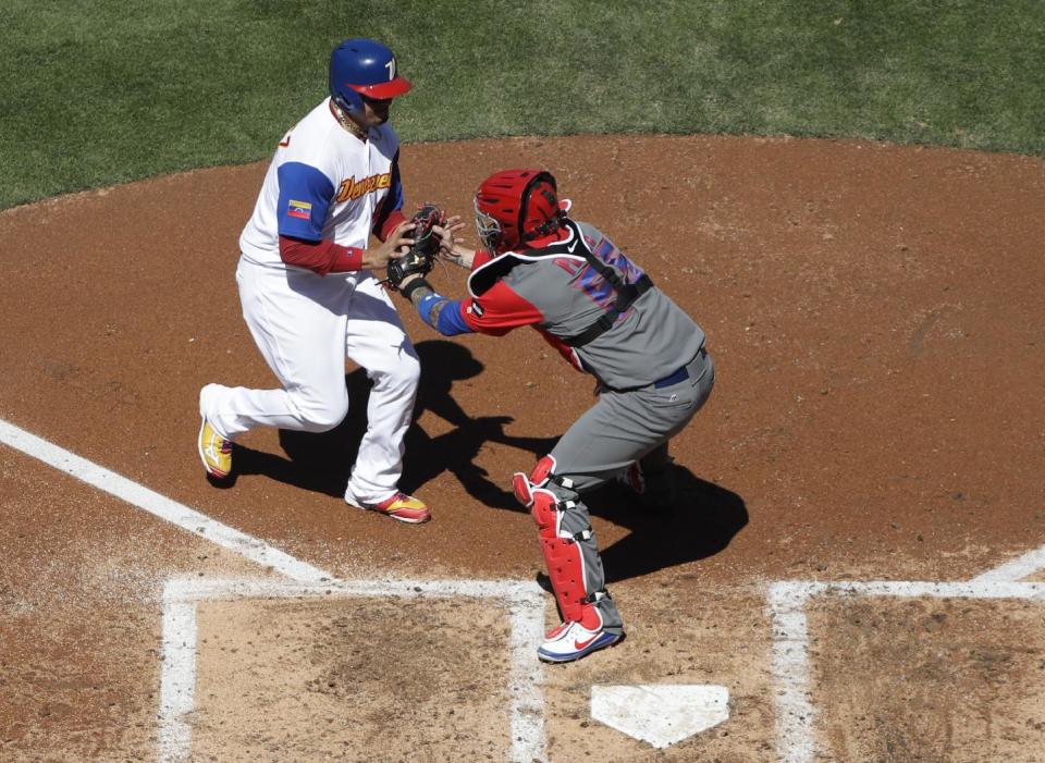 Puerto Rico catcher Roberto Perez (55) tags out Venezuela's Victor Martinez at home during the second inning of a second-round World Baseball Classic baseball game Saturday, March 18, 2017, in San Diego. (AP Photo/Gregory Bull)