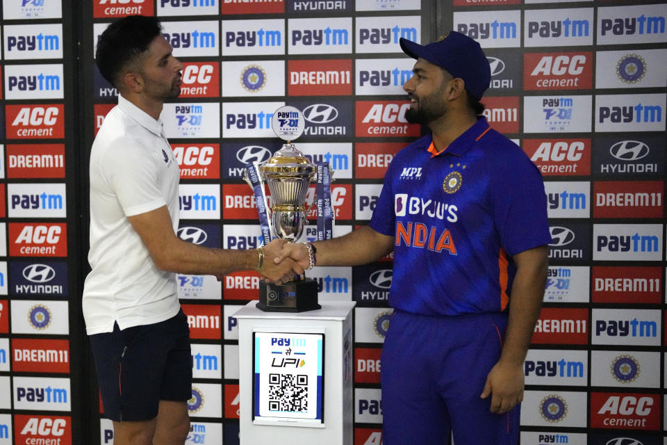 India's captain Rishabh Pant, right, shakes hands with South Africa's Keshav Maharaj after receiving the winners trophy after the last Twenty20 cricket match between India and South Africa was called off due to rain, in Bengaluru, India, Sunday, June 19, 2022. (AP Photo/Aijaz Rahi)
