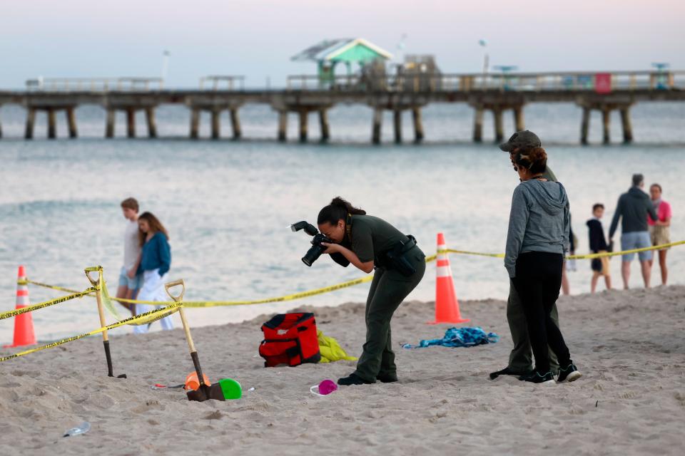 Investigators on the beach in Lauderdale-by-the-Sea, Fla., take photos of the scene of a sand collapse on Tuesday, Feb. 20, 2024. A young girl was buried in sand and died Tuesday when a deep hole she was digging with a little boy collapsed on them both at a south Florida beach, authorities said.