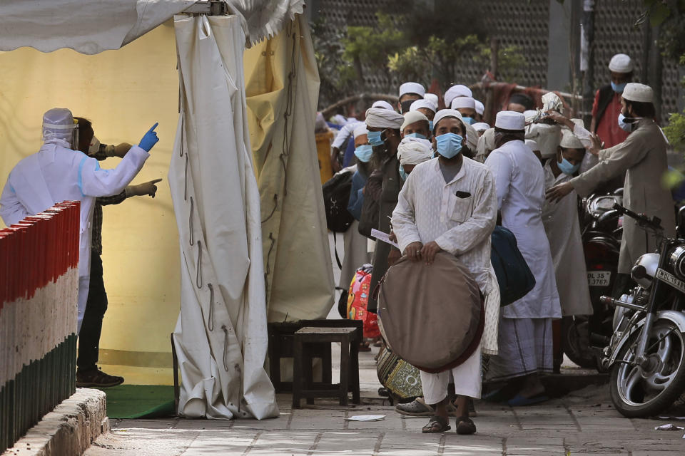 FILE - In this March 31, 2020, file photo, Indian paramedics note down the names of Muslims after screening them before they board a bus, after a government raid discovered the largest viral cluster in India at the Nizamuddin area of New Delhi, India. Muslims in India are being stigmatized after the government blamed an Islamic missionary meeting for a surge in coronavirus cases. Experts who have studied previous epidemics warn that the stigma could hamper efforts to stop the contagion and prevent many from getting themselves tested. (AP Photo/Manish Swarup, File)