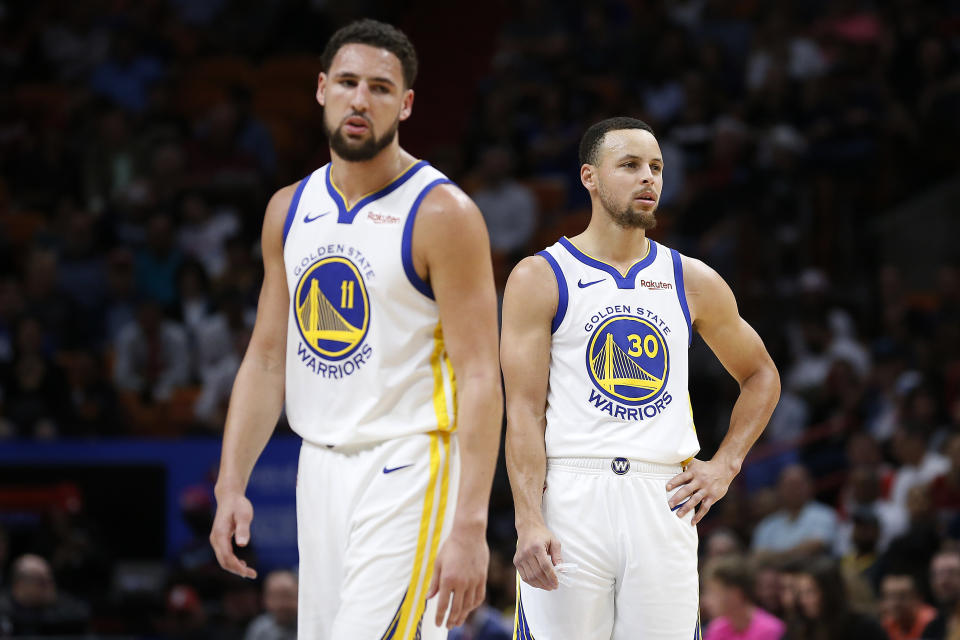 Klay Thompson #11 and Stephen Curry #30 of the Golden State Warriors look on against the Miami Heat at American Airlines Arena on February 27, 2019