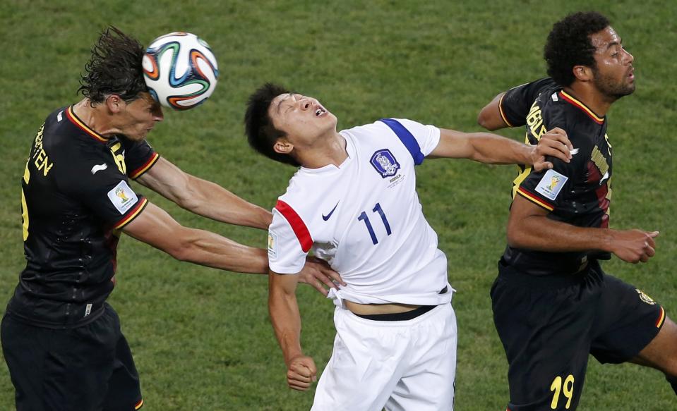 Belgium's Van Buyten heads the ball past South Korea's Lee and Belgium's Dembele during their 2014 World Cup Group H soccer match at the Corinthians arena in Sao Paulo