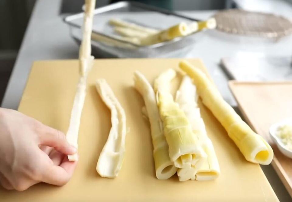 沿著切口將竹筍撕開，也可用刀切，但用撕的會比較入味。