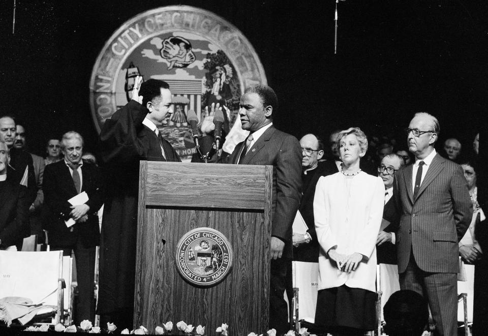 Harold Washington takes the oath of office becoming Chicago's 42nd mayor.  judge Charles Freeman, left, administered the oath on Friday, April 29, 1983, in Chicago.