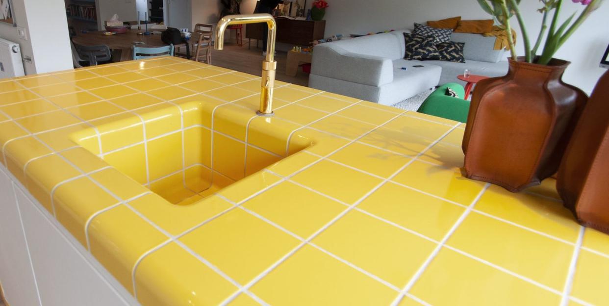 a room with a yellow and white tile floor and a couch