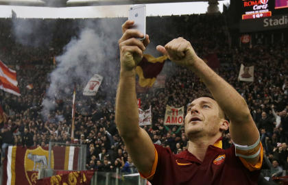 El capitán de la Roma Francesco Totti festeja un gol ante la Lazio tomándose una fotografía en el partido del domingo 11 de enero de 2015. (Foto AP/Gregorio Borgia)