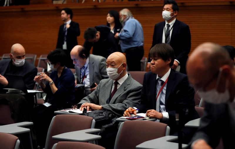 Media members wearing protective face masks, following an outbreak of the coronavirus, sit before a news conference by Japan's Prime Minister Shinzo Abe at his official residence in Tokyo
