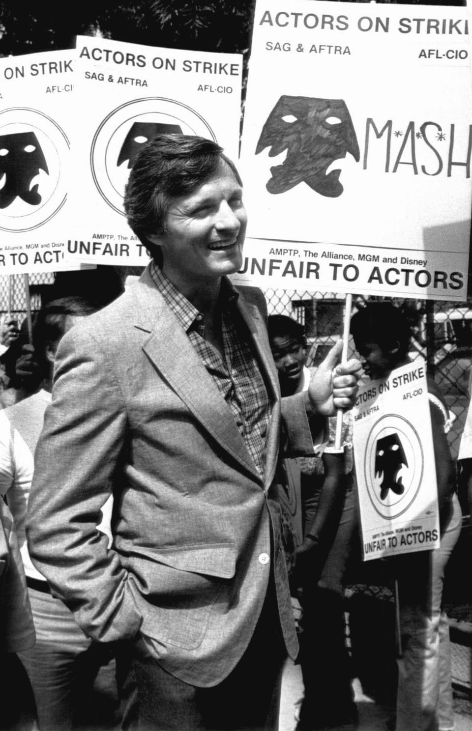 FILE - Actor Alan Alda, from the series "M*A*S*H*," pickets Twentieth-Century Fox studios in Los Angeles, Aug. 6, 1980. Alda said the actors who have been successful owe it to other actors to join the strike for fair wages. (AP Photo/Randy Rasmussen)