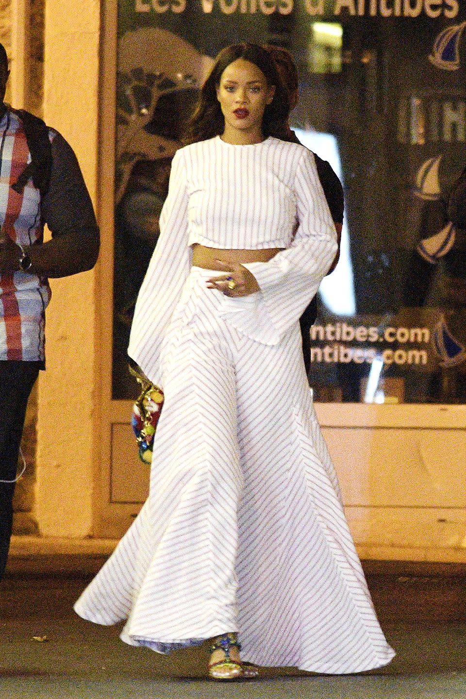 <p>In billowing pin-striped separates by Rosie Assoulin, multicolored sandals and a printed clutch while out for dinner in Antibes, France</p>