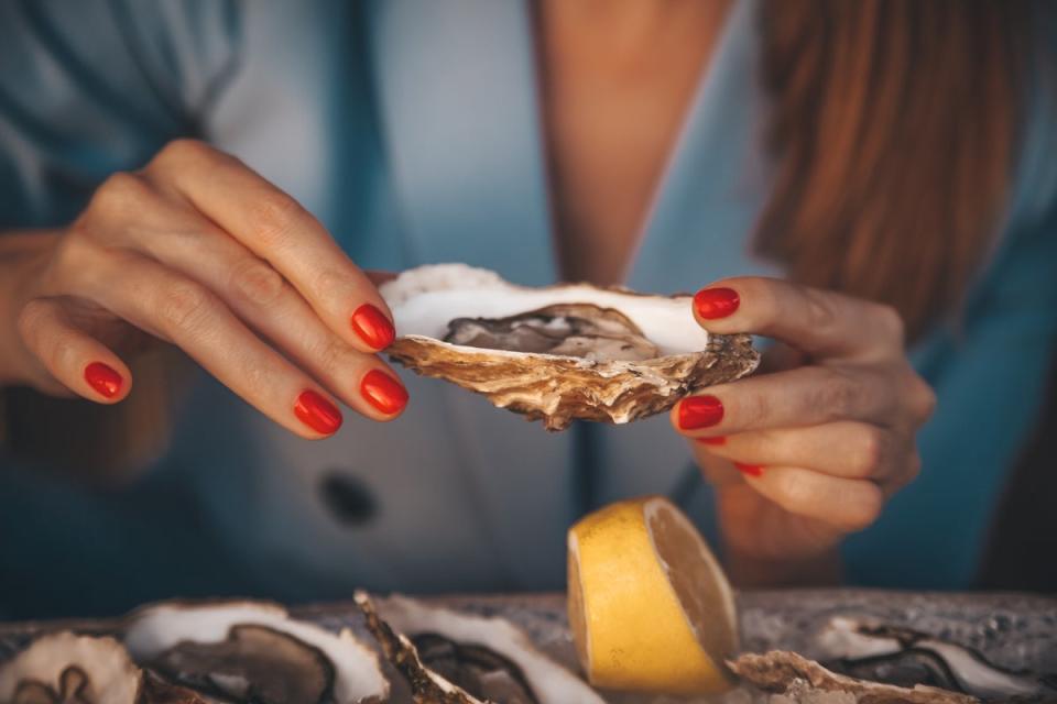 A woman prepares to engage in the saucy pastime of hoovering up oyster goo (Getty/iStock)