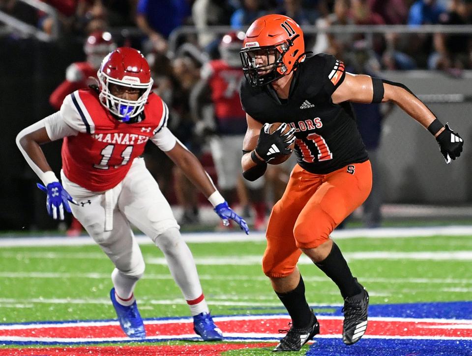 Sarasota's tight end Nathan Wells (11) pursued by Manatee's linebacker Elijah Perry (11). Manatee Hurricanes stay undefeated with a 27-14 win over the Sarasota Sailors at Joe Kinnan Field at Hawkins Stadium on Friday night, September, 1, 2023, in Bradenton.