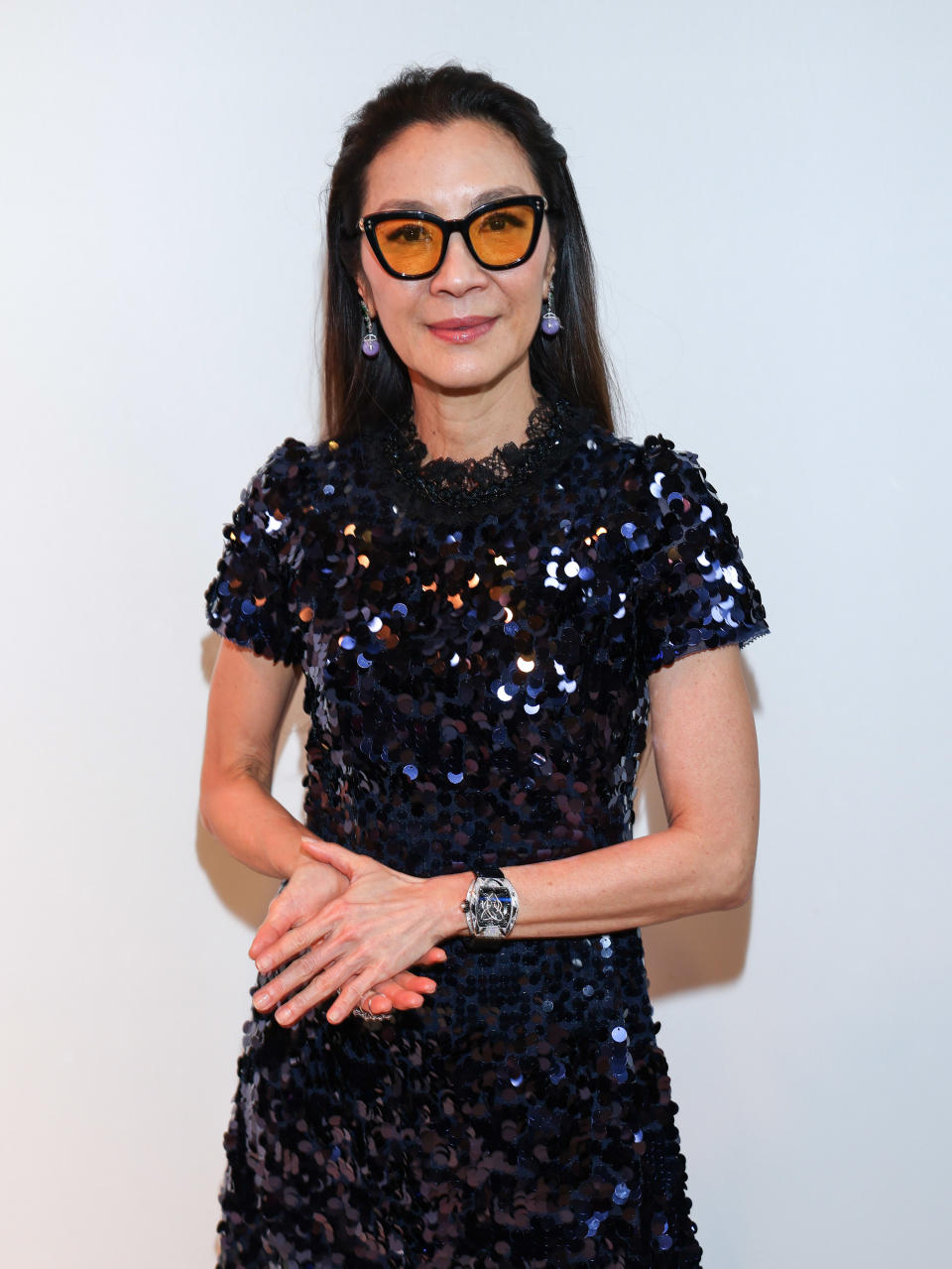 Michelle Yeoh posing in front of a white background