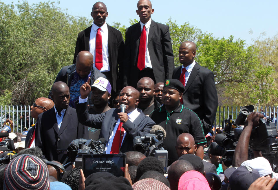 Firebrand politician Julius Malema, center, addresses his supporters after appearing at the Magistrate’s Court in Polokwane, South Africa, Wednesday, Sept. 26, 2012, on charges of money laundering in connection with an improper government tender awarded to a company his family trust partly owns. (AP Photo/Themba Hadebe)