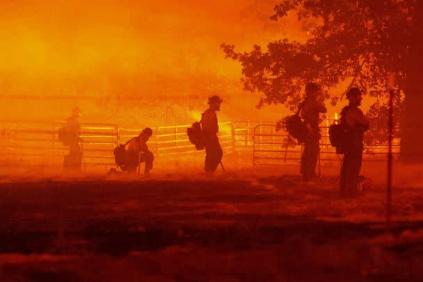 PHOTO: Firefighters look on as the Oak Fire burns in Darrah, in Mariposa County, Calif., July 22, 2022.  (David Swanson/Reuters)