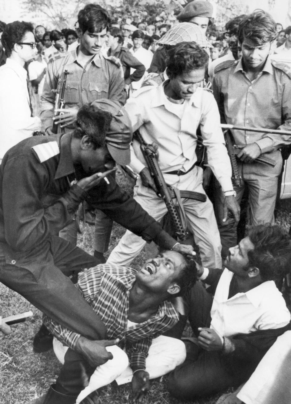 FILE - In this Dec. 18, 1971, file photo, Bangladeshi guerrillas beat a victim as they torture and execute four men suspected of collaborating with Pakistani militiamen accused of murder, rape and looting during months of civil war in Dacca, Bangladesh. Bangladesh is celebrating 50 years of independence this year. (AP Photo/Horst Faas, Michel Laurent, File)