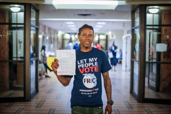 Michael Monfluery, a 38-year-old who has never been eligible to vote, shows off a certificate restoring his right after the special court hearing in Miami, Florida last month (Zak Bennett/AFP via Getty Images)