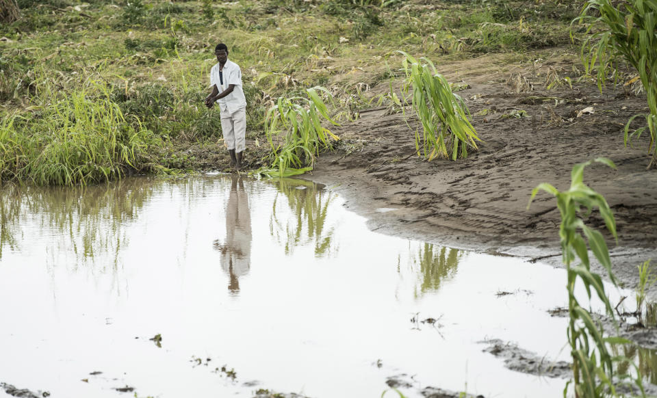 A men stands on his washed-away maize field in Chiradzulu, southern Malawi, Friday March 17, 2023. Authorities are still getting to grips with the scale of Cyclone Freddy's destruction in Malawi and Mozambique since late Saturday, with over 300 people confirmed dead and several hundreds still displaced or missing. (AP Photo/Thoko Chikondi)